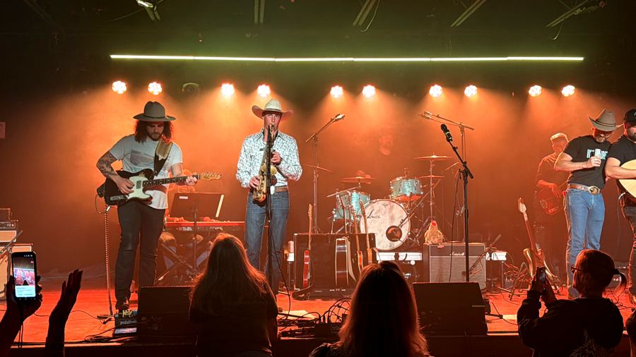Davis on also sax center stage under amber lights with guitar and drums
